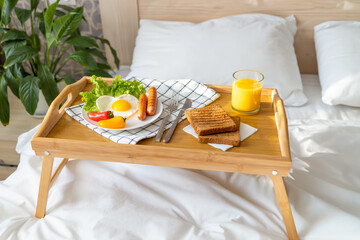 Breakfast on a tray in bed. Morning. Fried eggs in the shape of a heart with vegetables.