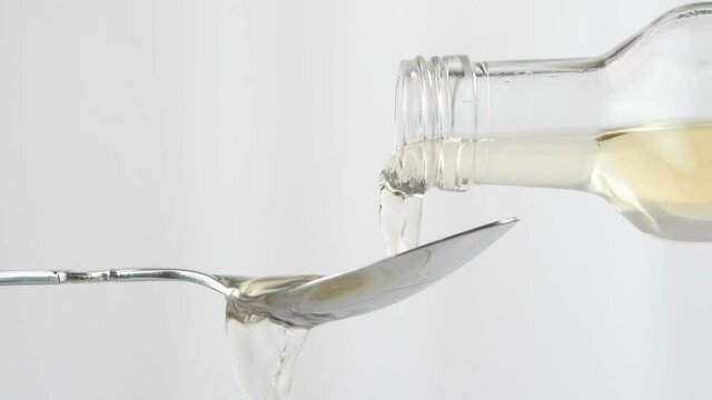 Pouring apple cider vinegar in a spoon