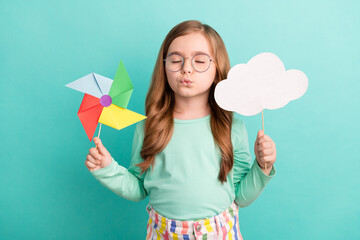 Obraz na płótnie Canvas Photo of young little girl pouted lips hold cloud windmill toy dream isolated over teal color background