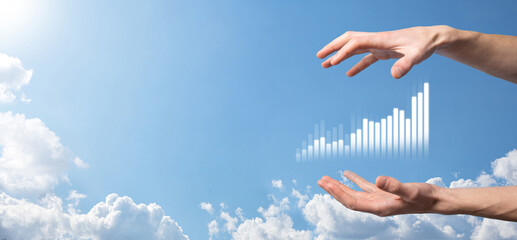 Business man holding tablet and showing holographic graphs and stock market statistics gain profits. Concept of growth planning and business strategy. Display of good economy form digital screen.