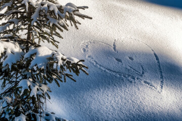 Shape of smiling heart in snow. Winter love