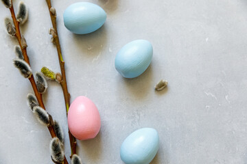 Happy Easter concept. Preparation for holiday. Colorful decorated easter eggs willow on concrete stone grey background. Simple minimalism flat lay top view copy space