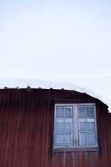 Closeup on red wall with snow covered roof