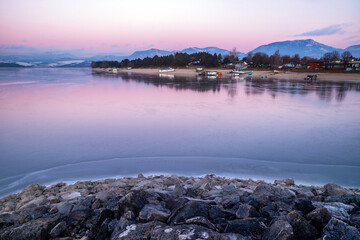 A beautiful pink sky in the morning during sunrise on a lake. Winter landscape in bright colors.Dam Liptovska Mara, Slovakia.
