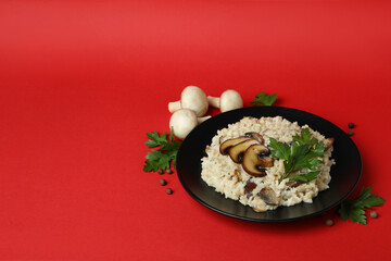 Concept of tasty food with risotto with mushrooms on red background