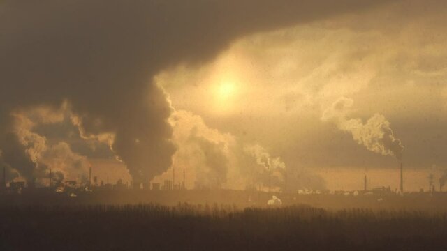 Factory chimneys pollute the air, environmental problems. It's snowing ash at sunset. Industrial pollution, exhaust fumes from the chimney. Industrial area, thick smoke. Climate change, ecology, atmos