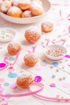 Krapfen, Berliner and donuts with streamers and confetti. Colorful carnival or birthday image