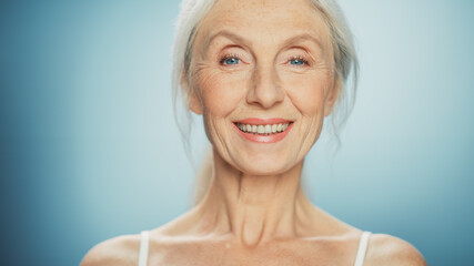 Close-up Portrait of Beautiful Senior Woman Looking at Camera and Smiling Wonderfully. Gorgeous...