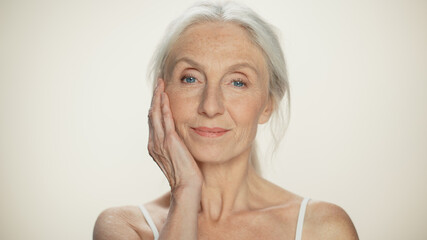 Closeup Portrait of Senior Woman Looking at Camera, Touching Hair, Beautiful Face, Smiling. Elderly...