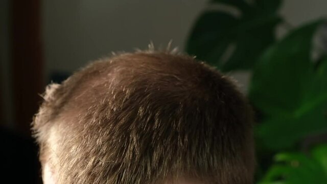 A man is getting a haircut with an electric clipper at home. Home haircut. Savings on hairdresser.