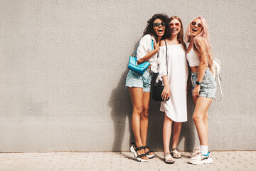 Three young beautiful smiling female in trendy summer clothes.Sexy carefree multiracial women...