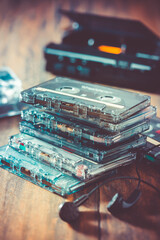Closeup of cassette tape, tape player and headphones on wooden background