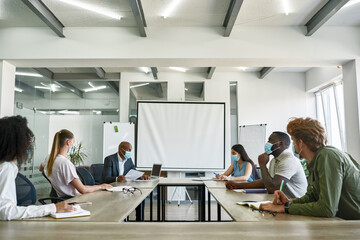 Fototapeta premium Office workers look on boss at corporate meeting