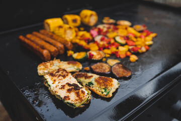 vegan barbecue with grilled vegetables plant-based sausages and corn on the cob, healthy plant-based food