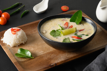 Tom Kha Gai soup with chicken, cherry tomato, coconut milk, kaffir, galangal, lemongrass,mushrooms. Thai food. Coconut Chicken Soup. Close up.