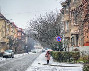 Snow covered streets of the winter old town, frosty weather, a woman alone with an umbrella in a residential area, a view of the city of Uzhhorod, Transcarpathia Uzhgorod Ukraine