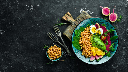 Diet salad: Chickpeas, spinach, radishes, avocados and eggs. Bowl Buddha. Vegan food. Top view. On a stone background.
