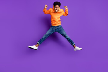 Fototapeta na wymiar Full length body size view of attractive cheerful guy jumping rejoicing isolated over bright violet purple color background