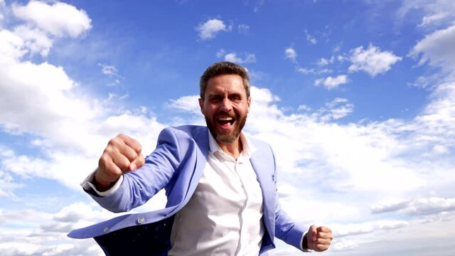 Happy successful businessman scream making winning gesture on sky, success