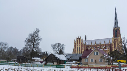 Obraz premium Old house and church. A small house behind which you can see a large church. Space for text.