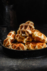 Belgian waffles with honey on a dark background