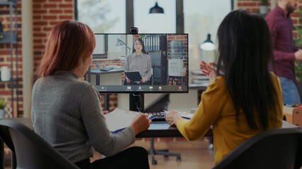 Asian women interviewing candidate to fill job vacancy on video call in startup office. Company workers meeting with woman to hire intern on contract, using online videoconference on computer.