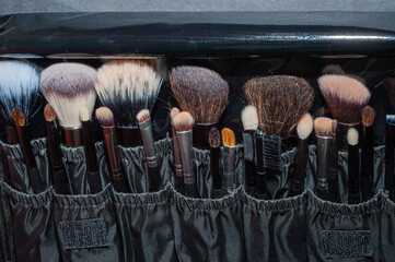 Makeup brushes on a black background, with a place to insert text,