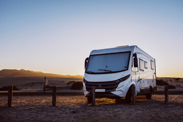 Big motorhome camper parked off road with desert and blue sky in background. Travel lifestyle...