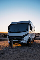 Big motorhome camper parked off road with desert and blue sky in background. Travel lifestyle...