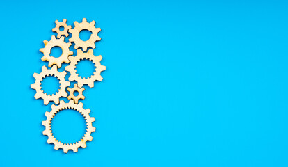 Wooden cogwheels on blue background 