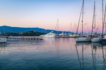 Fototapeta na wymiar Pier with motorboats and yachts moored alongside at sunset