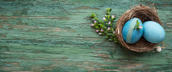 Easter still life on green weathered wood. Horizontal easter background with space for text. Top view.
