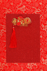 Red fabric with dragon pattern with red copy space for text and golden female hairpin. Concept of...
