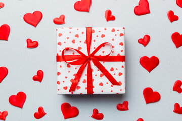Valentine day composition Background: red gift box with bow and heart. Christmas present. View from above. Holday greeting card