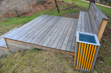 wooden staircase serves as a theater bench overlooking river. park promenade with original wooden...