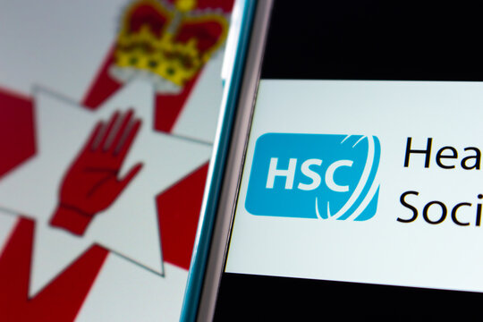 Kumamoto, JAPAN - Sep 6 2021 : Closeup Health And Social Care (HSC), The Publicly Funded Healthcare System In Northern Ireland Created Separately To The NHS In UK, On IPhone On Northern Ireland Flag