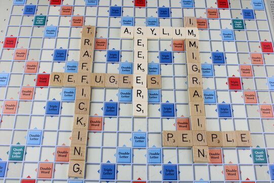 Asylum Seekers, Refugees, Immigration And People Trafficking On A Scrabble Board With Asylum Seekers In White For Emphasis. Lancashire, UK, 25-11-2021