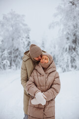 Fototapeta na wymiar Loving couple hugging in the winter forest