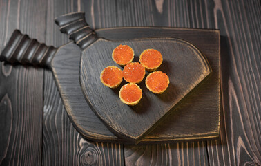 Tartlet with red caviar on wooden boards in a rustic style. Top view.