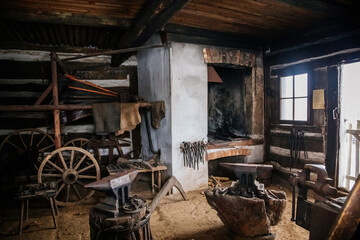 Kourim, Bohemia, Czech Republic, 26 December 2021: Interior of Traditional village house, country-style architecture, open-air ethnographic museum, forge with anvil hammers and pliers, iron horseshoes