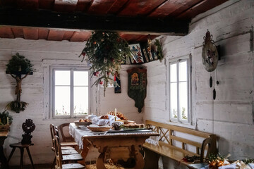 Kourim, Czech Republic, 26 December 2021: Interior of Traditional village house, benches and table, tree upside down, country-style architecture, Christmas in Skanzen, open-air ethnographic museum