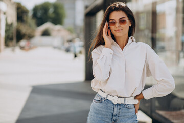 Young woman in white shirt walking outside summer streets