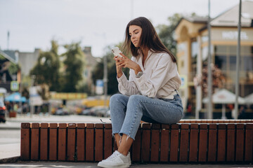 Young woman talking on the phone outside the street