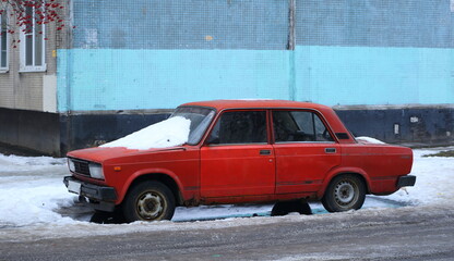 Old red rusty car with snow on the hood, Podvoysky Street, St. Petersburg, Russia, St. Petersburg, January 2022