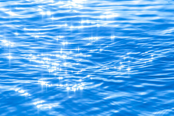 Sun light reflecting or sparkling glitter on water of sea or ocean with beautiful sky blue light tone.