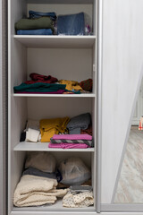 Fototapeta na wymiar wardrobe compartment with sliding door with things on the shelves