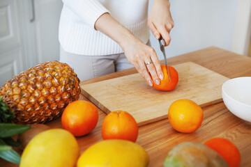 Girl hands cutting fruits on cutting board, close up shot. Healthy eating concept