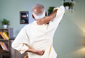 Rear view of Sick old man stretching by holding neck and back spain - concept of suffering from...