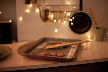 Leftover cookies on the oven tray in the kitchen with lights at night. Midnight snack