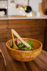 eco wooden bamboo bowl of green salad in the kitchen - vegan food and healthy eating